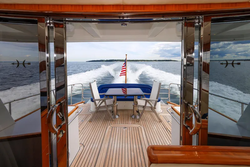 Slide: The Image of 2009 Hunt Yachts 52 Express deck with American flag and seating area on open water. - 22