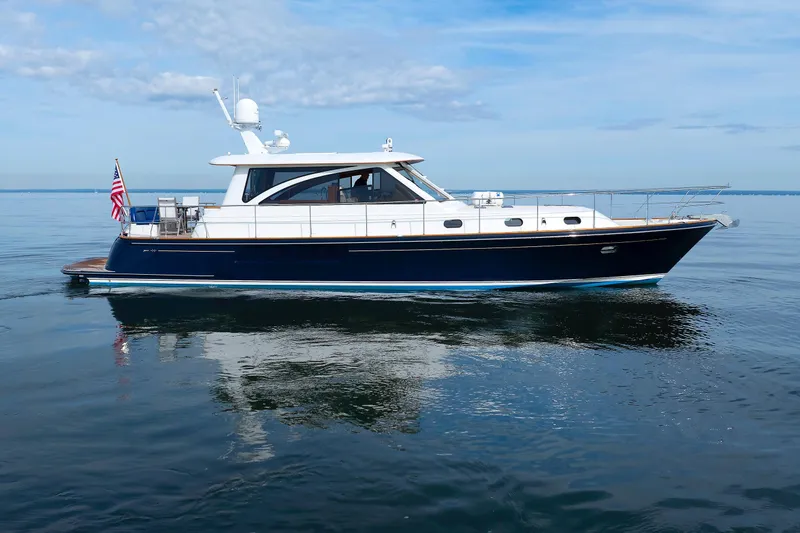 Slide: The Image of 2009 Hunt Yachts 52 Express on calm water, displaying American flag. - 59