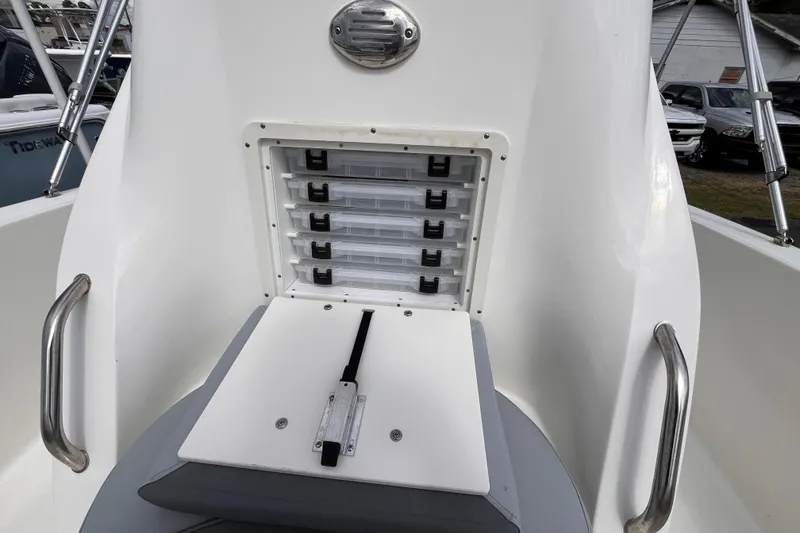 Slide: The Image of 2023 NauticStar 191 Hybrid boat storage compartment with tackle boxes and stainless steel handles. - 10