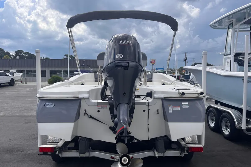 Slide: The Image of 2023 NauticStar 191 Hybrid boat with outboard motor, parked on a trailer. - 3