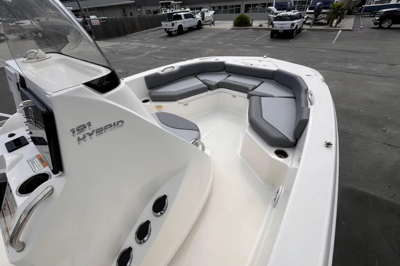 Slide: The Image of 2023 NauticStar 191 Hybrid boat with spacious seating in a parking lot. - 8