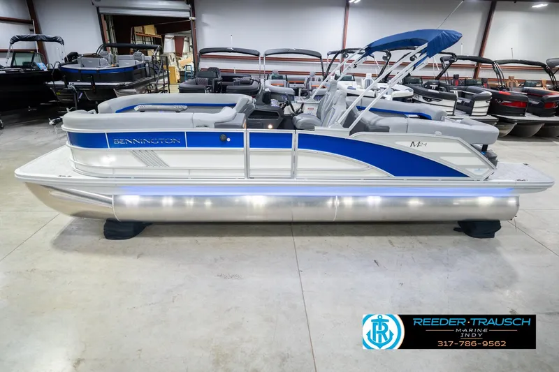 The Image of 2026 Bennington 24 MOFB pontoon boat in showroom, featuring blue and silver design. - 2
