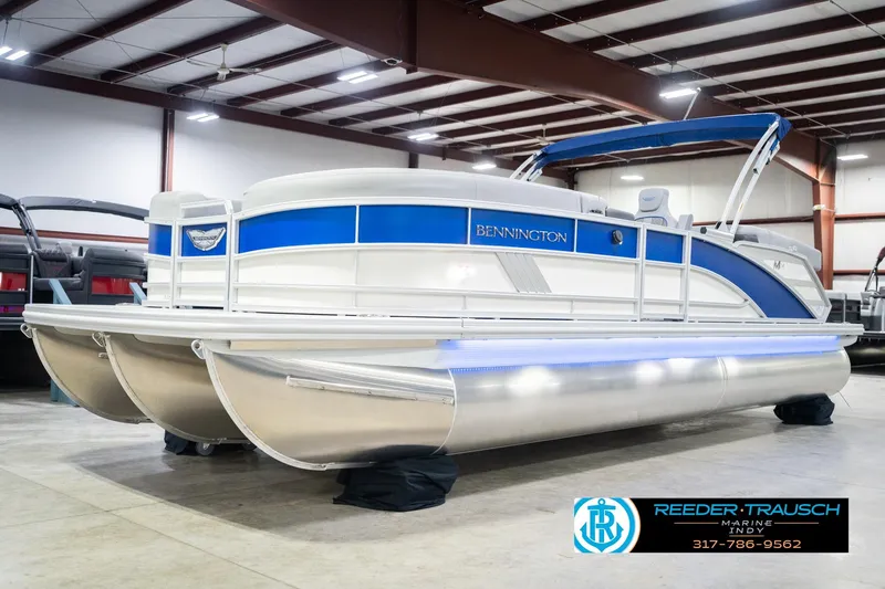 Slide: The Image of 2026 Bennington 24 MOFB pontoon boat in showroom with blue accents and canopy. - 3