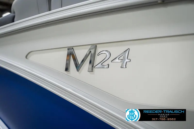 Slide: The Image of 2026 Bennington 24 MOFB boat with M24 emblem, blue and white design. - 56