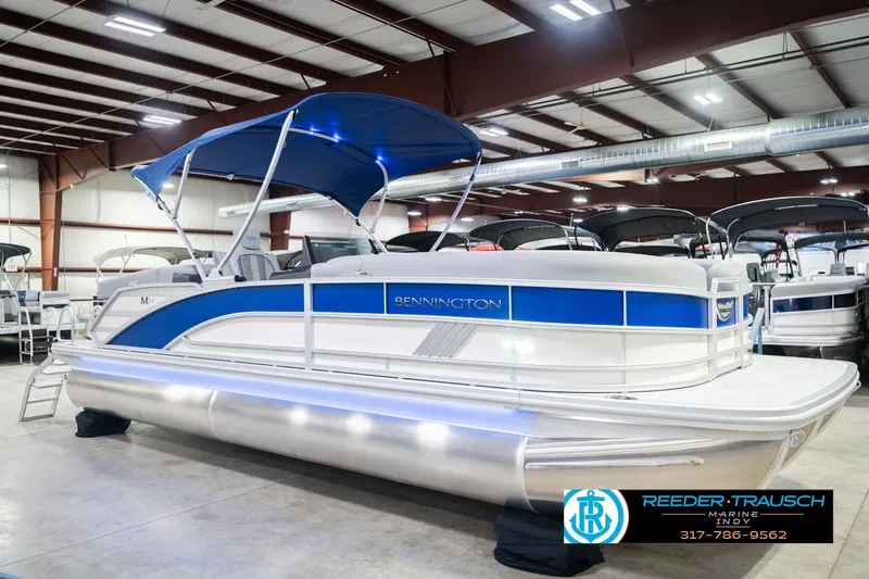 Slide: The Image of 2026 Bennington 24 MOFB pontoon boat with blue canopy in showroom. - 6