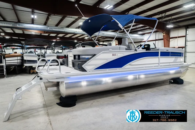 Slide: The Image of 2026 Bennington 24 MOFB pontoon boat with blue canopy in showroom. - 8