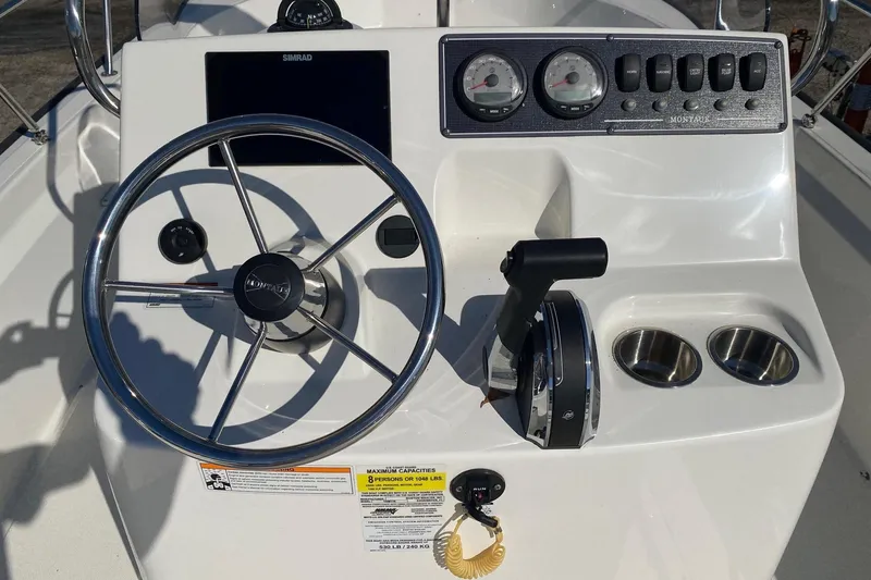 Slide: The Image of 2023 Boston Whaler 190 Montauk boat console with steering wheel and controls. - 10