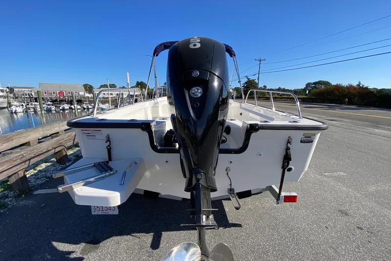 Slide: The Image of 2023 Boston Whaler 190 Montauk boat with outboard motor, docked near marina. - 3