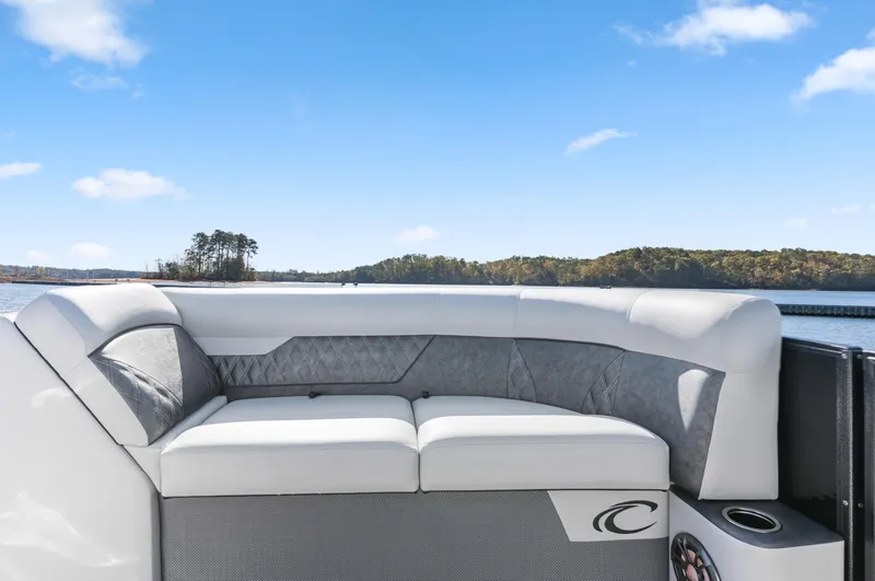 Slide: The Image of 2021 Crest Classic DLX 220 SLRC boat interior with plush seating and scenic lake view. - 12