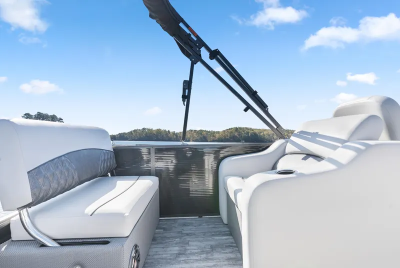 Slide: The Image of 2021 Crest Classic DLX 220 SLRC boat interior with comfortable seating and scenic lake view. - 14