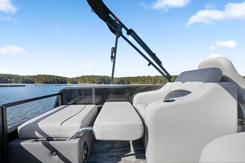 Slide: The Image of 2021 Crest Classic DLX 220 SLRC boat interior with plush seating on a sunny day. - 18