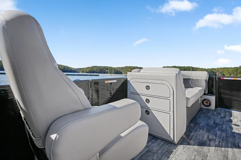 Slide: The Image of 2021 Crest Classic DLX 220 SLRC pontoon boat interior with gray seating and scenic lake view. - 19