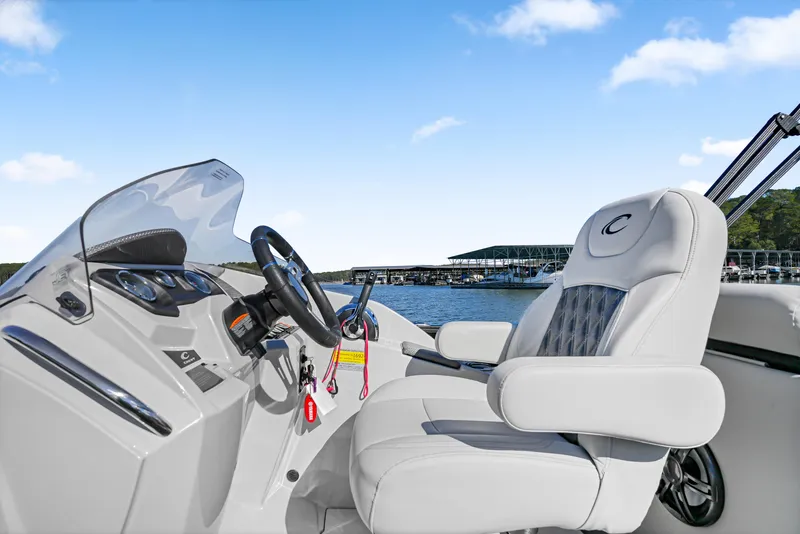 Slide: The Image of 2021 Crest Classic DLX 220 SLRC boat interior with steering wheel and captain's chair. - 21