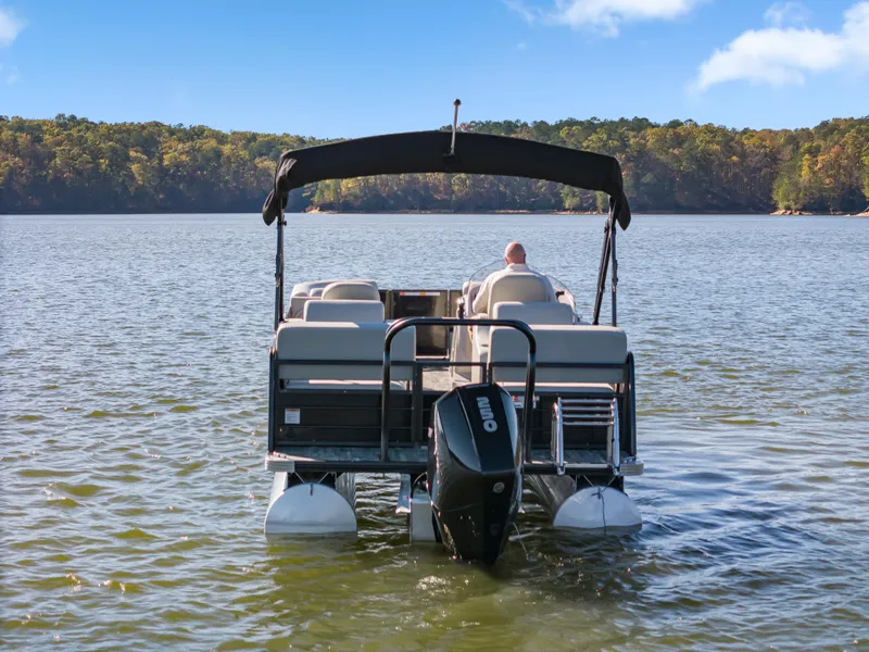 Slide: The Image of 2021 Crest Classic DLX 220 SLRC pontoon boat on a serene lake. - 4