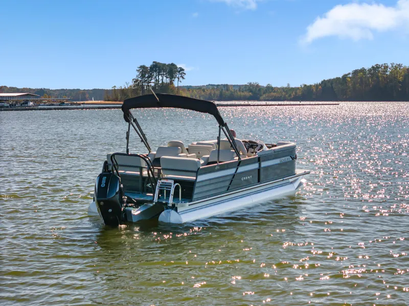 Slide: The Image of 2021 Crest Classic DLX 220 SLRC pontoon boat on a sunny lake. - 5