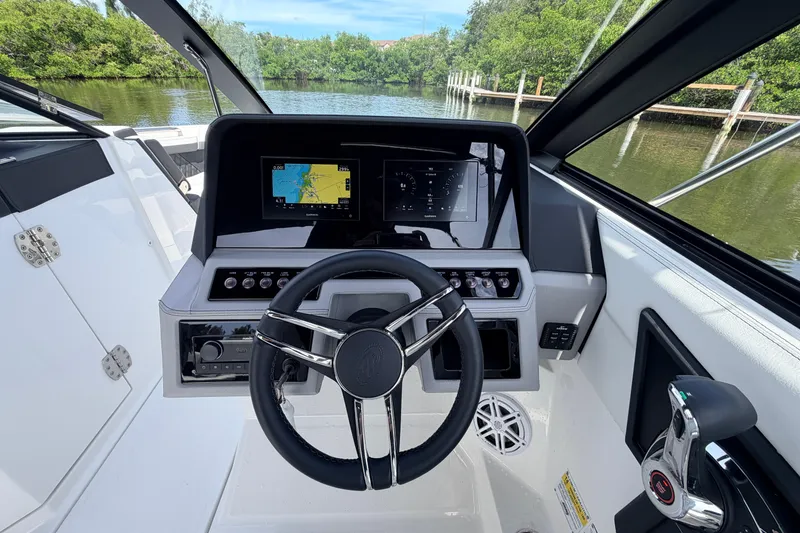 Slide: The Image of 2026 Cobalt R6 Outboard boat dashboard with steering wheel and navigation screens. - 16