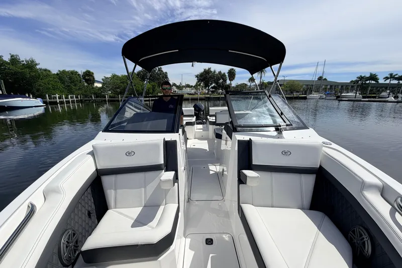 Slide: The Image of 2026 Cobalt R6 Outboard boat with sleek interior design, docked on a calm waterway. - 19