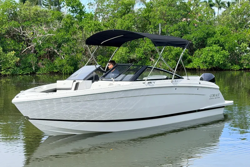 Slide: The Image of 2026 Cobalt R6 Outboard boat cruising on a calm river with lush greenery. - 3