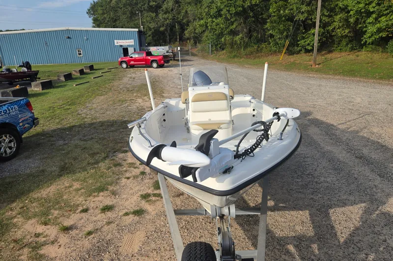 Slide: The Image of 2016 Key West 176 Center Console boat on trailer, parked outdoors near a blue building. - 3