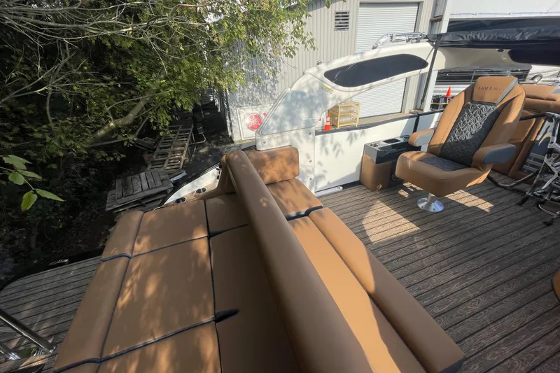 Slide: The Image of 2026 Harris Grand Mariner 230 SLDH boat interior with tan seating and wood deck. - 18