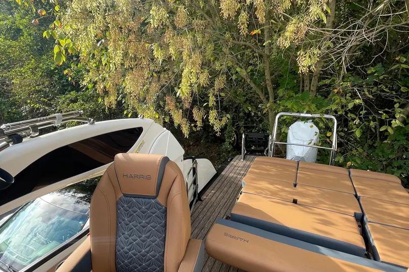 Slide: The Image of 2026 Harris Grand Mariner 230 SLDH boat with luxurious seating, surrounded by lush greenery. - 20