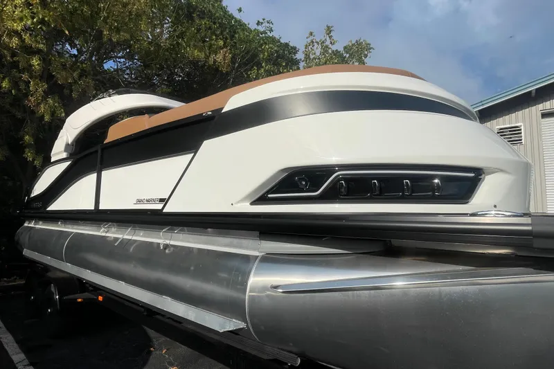 Slide: The Image of 2026 Harris Grand Mariner 230 SLDH pontoon boat, sleek design, parked outdoors. - 3