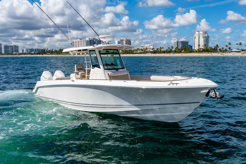 The Image of 2022 Boston Whaler 330 Outrage boat cruising on ocean near city skyline. - 0