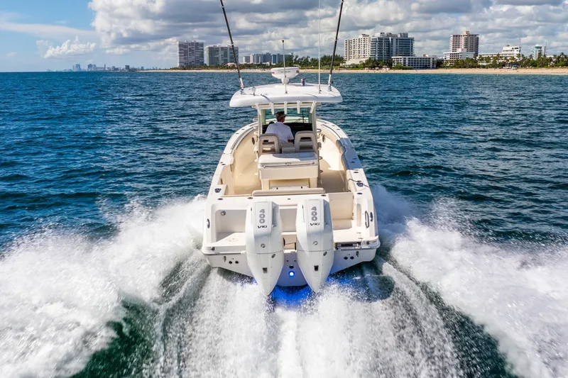 Slide: The Image of 2022 Boston Whaler 330 Outrage cruising on ocean near city skyline. - 12