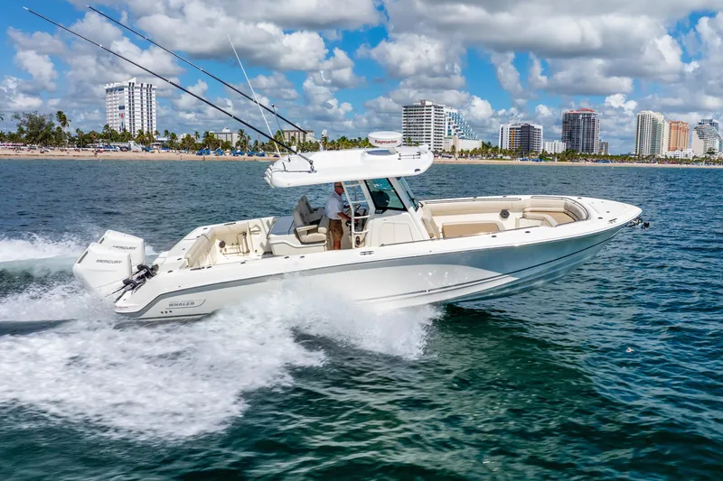 Slide: The Image of 2022 Boston Whaler 330 Outrage cruising on ocean near city skyline. - 17