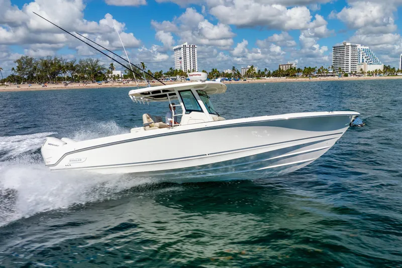 Slide: The Image of 2022 Boston Whaler 330 Outrage cruising on ocean near city skyline. - 18