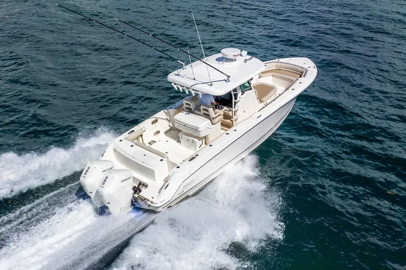 Slide: The Image of 2022 Boston Whaler 330 Outrage cruising on open water, showcasing powerful twin engines. - 21