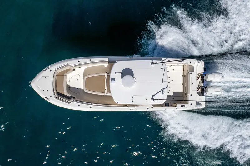 Slide: The Image of Top view of 2022 Boston Whaler 330 Outrage cruising on water. - 24