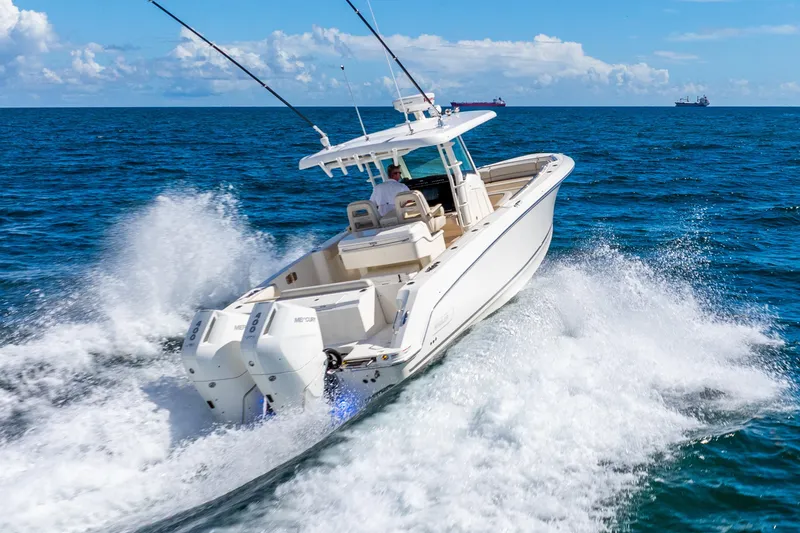 Slide: The Image of 2022 Boston Whaler 330 Outrage cruising on open ocean, creating dynamic water splashes. - 25
