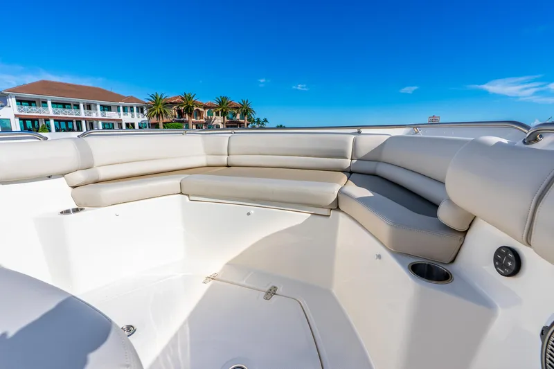 Slide: The Image of 2022 Boston Whaler 330 Outrage boat interior with luxurious seating and coastal view. - 27