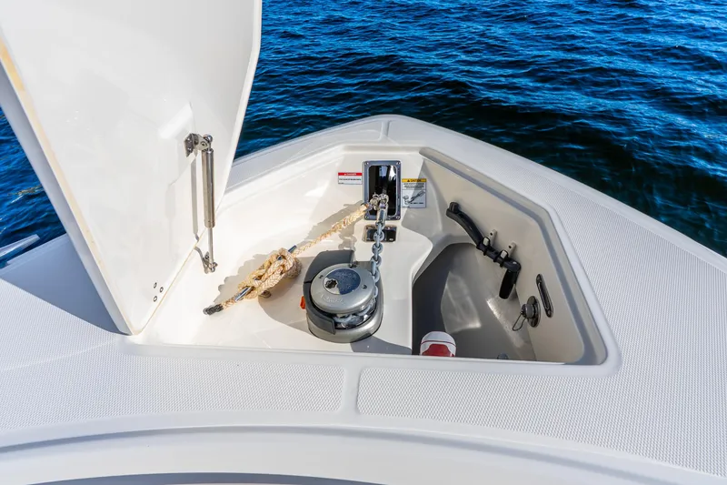 Slide: The Image of 2022 Boston Whaler 330 Outrage anchor compartment with chain and rope on open water. - 28