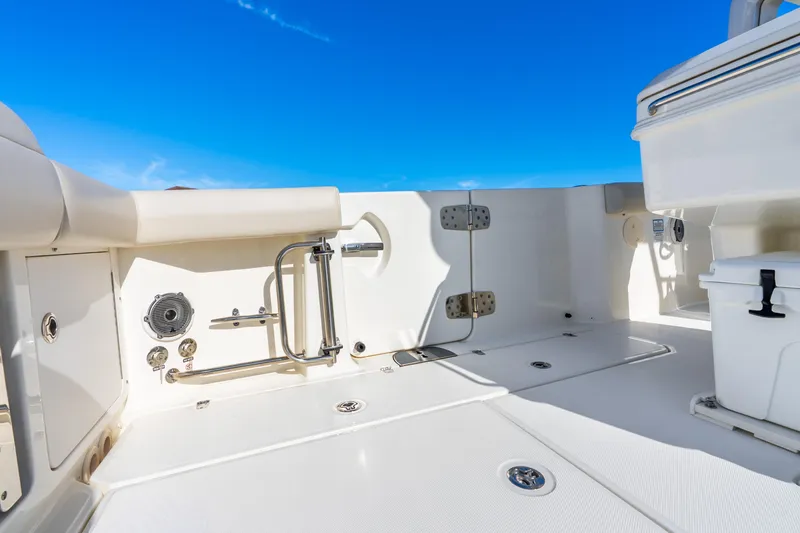 Slide: The Image of 2022 Boston Whaler 330 Outrage boat deck with storage and seating under clear blue sky. - 32