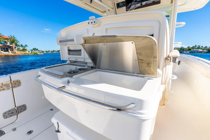 Slide: The Image of 2022 Boston Whaler 330 Outrage boat interior with open storage compartment, near waterfront. - 34