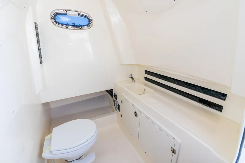 Slide: The Image of 2022 Boston Whaler 330 Outrage interior bathroom with toilet and sink. - 47