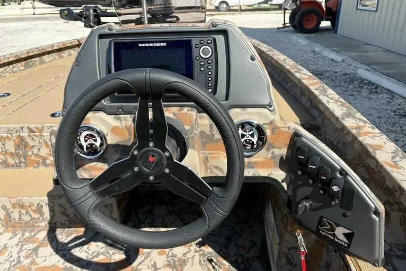 Slide: The Image of 2026 Xpress H20 Bass boat dashboard with steering wheel and Humminbird display. - 10