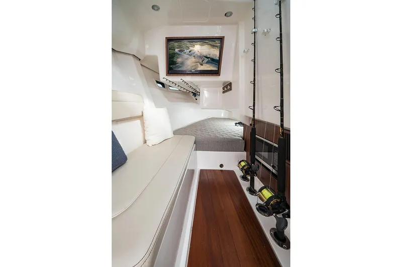 Slide: The Image of Manufacturer Provided Image: 2025 Pursuit DC 365 Dual Console cabin interior with fishing rods and seating. - 30