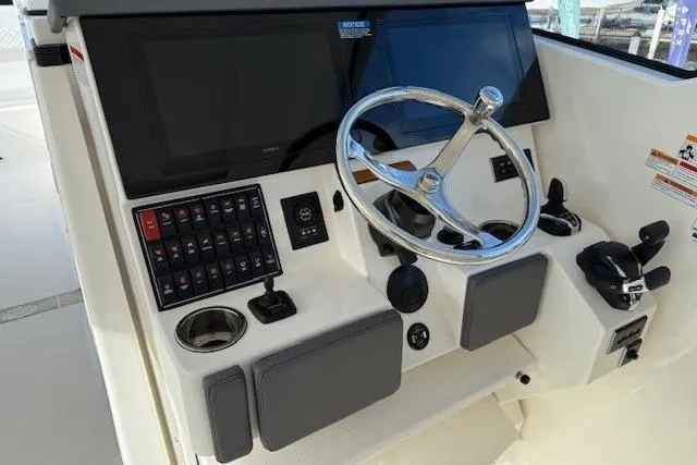 Slide: The Image of 2025 Pursuit DC 365 Dual Console boat dashboard with steering wheel and control panel. - 6