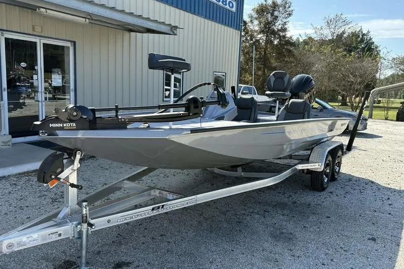 Slide: The Image of 2026 Xpress H20 Bass boat on trailer, parked outside a building. - 15