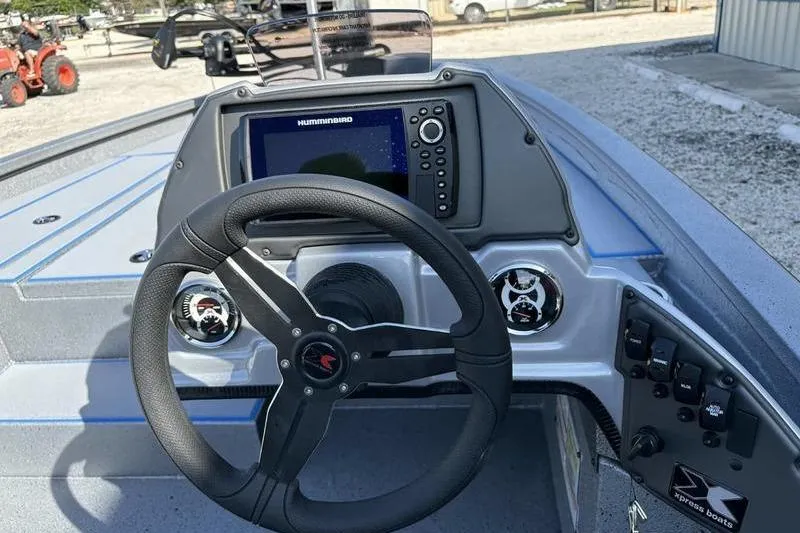 Slide: The Image of 2026 Xpress H20 Bass boat dashboard with steering wheel and Humminbird navigation system. - 2