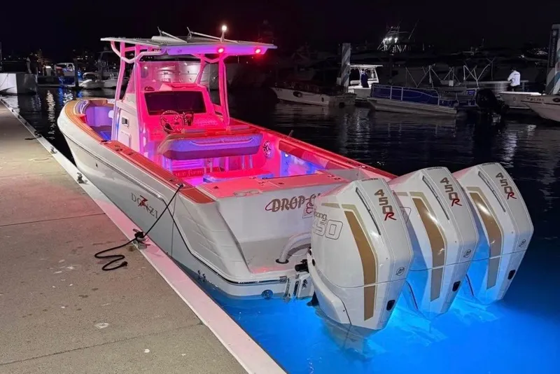 Slide: The Image of 2001 Donzi 32 VS boat docked at night, illuminated with vibrant pink and blue lights. - 3