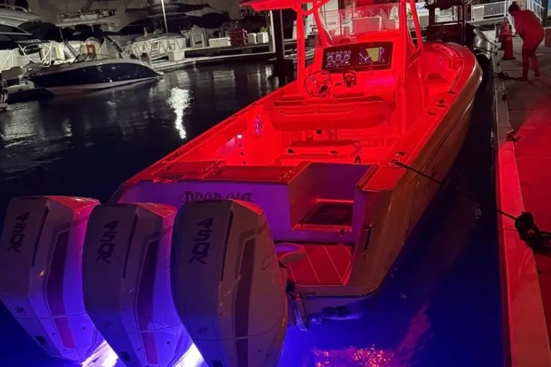 Slide: The Image of 2001 Donzi 32 VS boat with red interior lighting and triple 450R engines at a marina. - 4