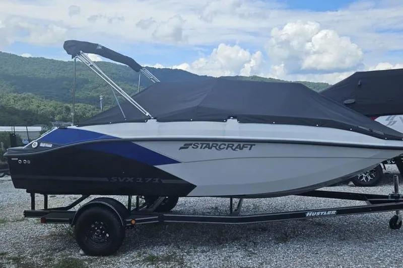 Slide: The Image of 2023 Starcraft SVX 171 OB boat on trailer, covered, with scenic mountain backdrop. - 3
