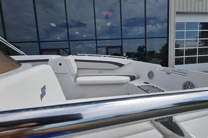 Slide: The Image of 2023 Starcraft SVX 171 OB boat interior with seating and speakers, outside a showroom. - 6