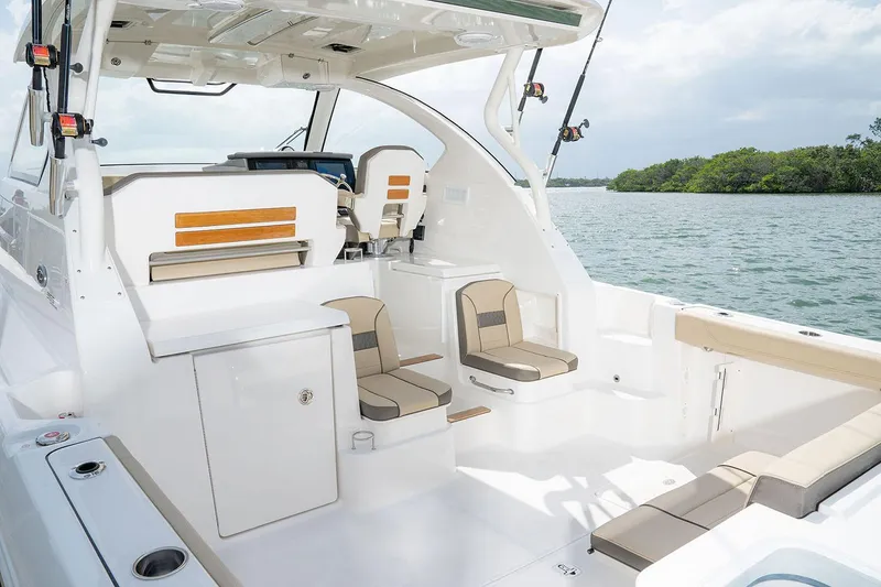 Slide: The Image of Manufacturer Provided Image: 2025 Pursuit OS 355 Offshore boat interior with seating, on a calm water backdrop. - 9
