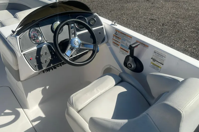 Slide: The Image of 2022 Hurricane Sundeck Sport 218 OB boat cockpit with steering wheel and controls. - 10