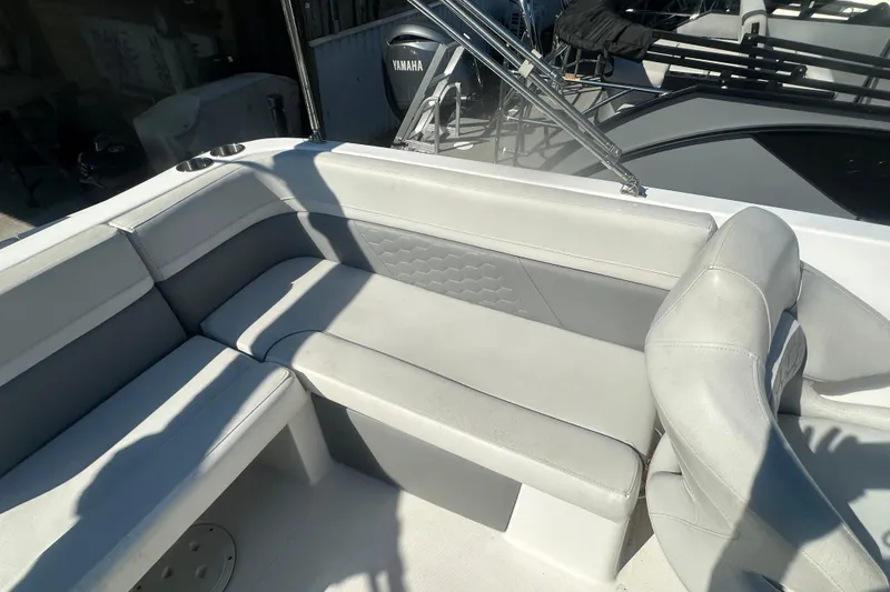 Slide: The Image of 2022 Hurricane Sundeck Sport 218 OB boat interior with gray seating and Yamaha engine. - 23